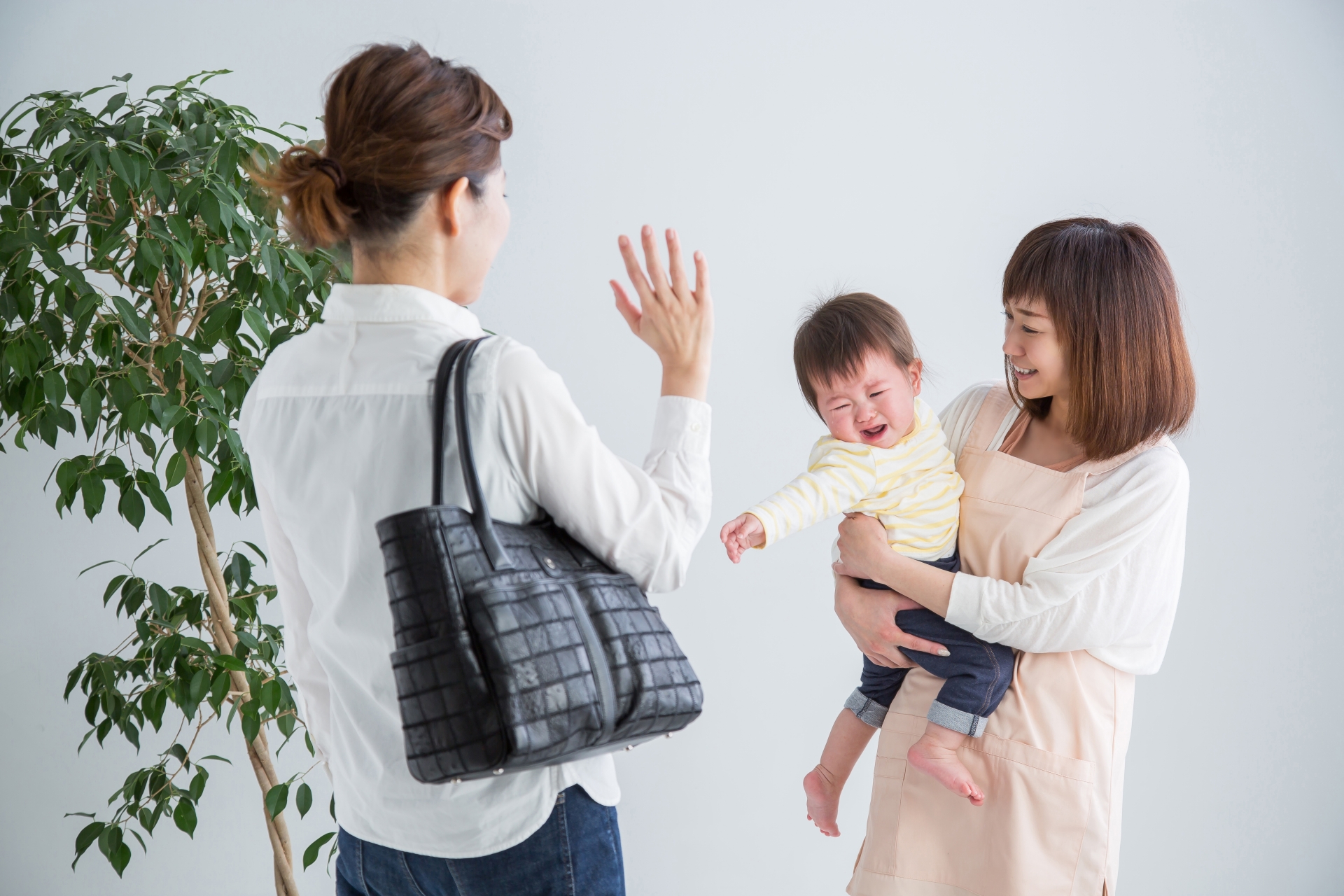 保育士に子どもを預ける女性
