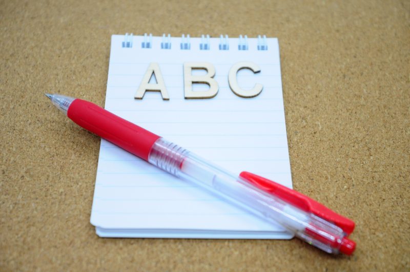 ABCと書かれたメモと赤いペン