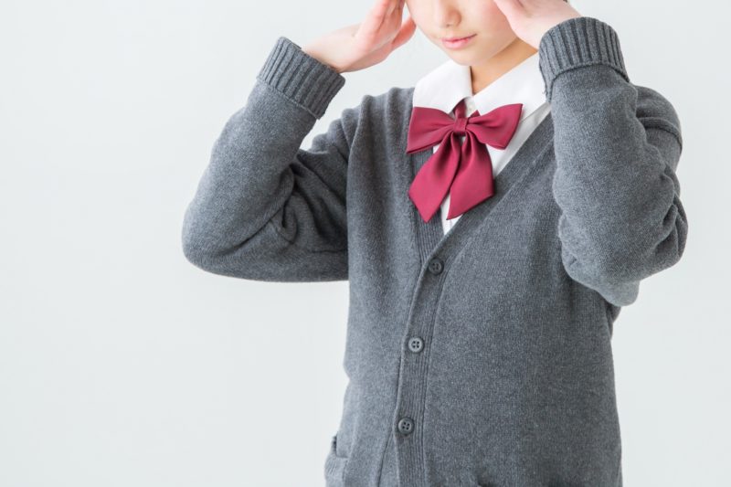 頭を両手で抱える女子生徒