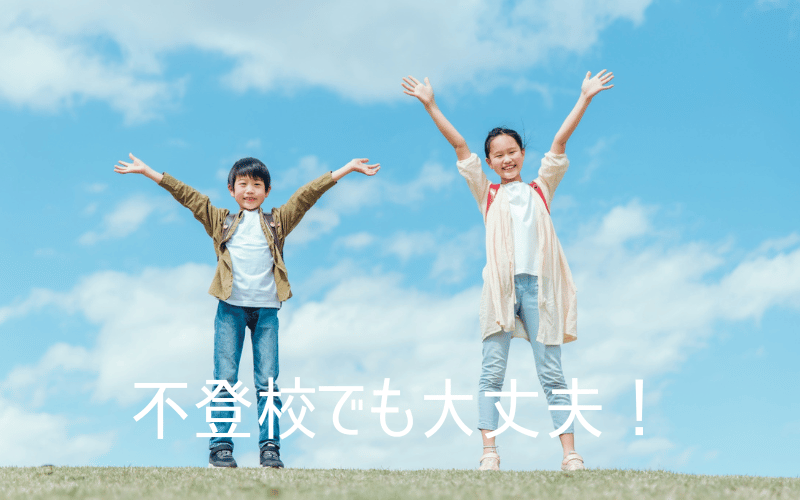 青空の下、芝生の上で両手を広げる男児と女児