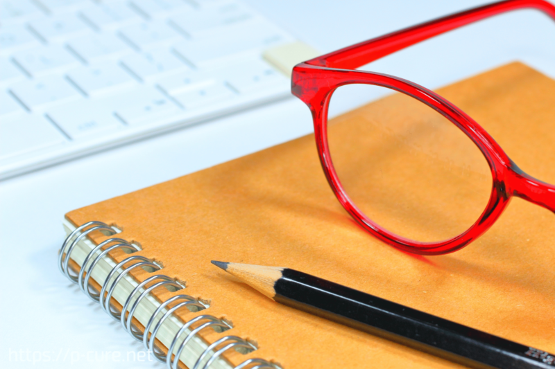 ノートと赤い眼鏡と鉛筆とキーボード