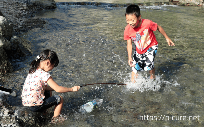 川遊びをする２人の子ども