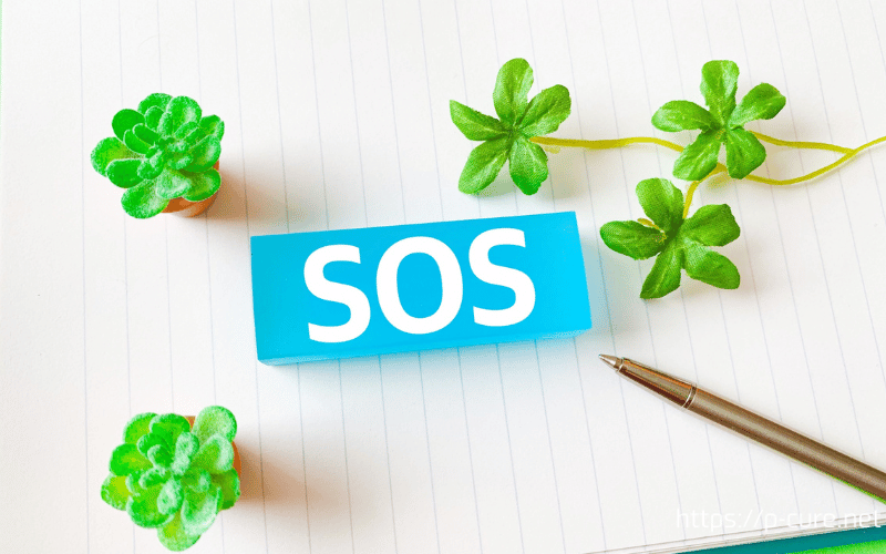 ノートとペンと「SOS」の文字