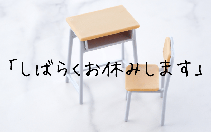 机と椅子と「しばらくお休みします」の文字