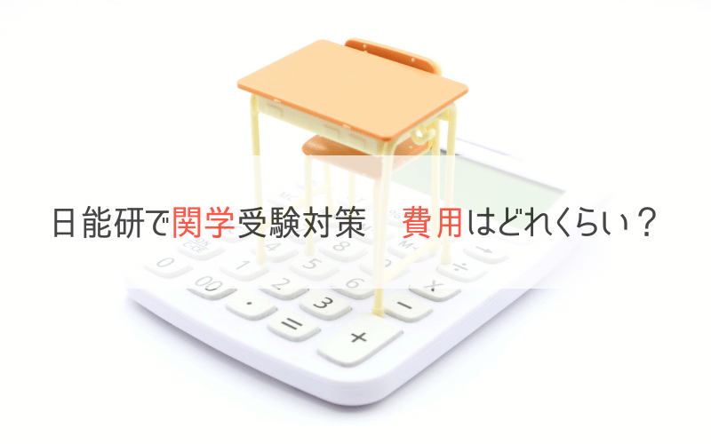 電卓と机と椅子、「日能研で関学受験対策　費用はいくら？」の文字