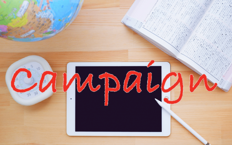 タブレットと時計、地球儀と「campaign」の赤い文字