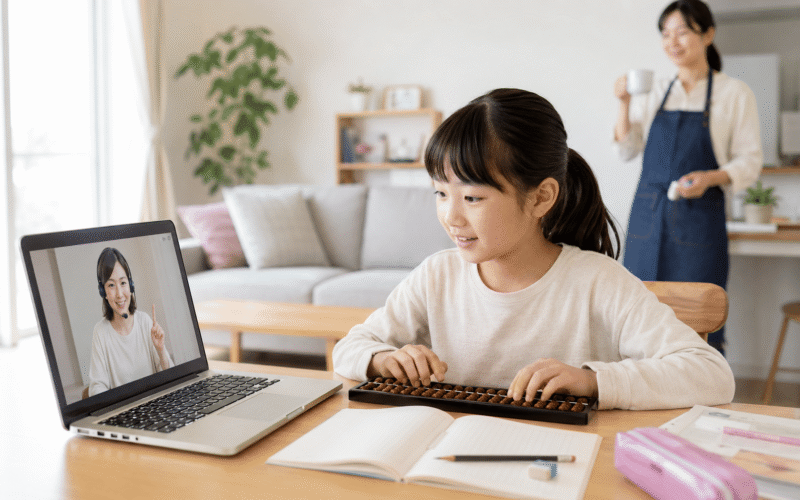 小学生が一人でオンラインそろばんレッスンを受講し、保護者は離れて見守っている様子